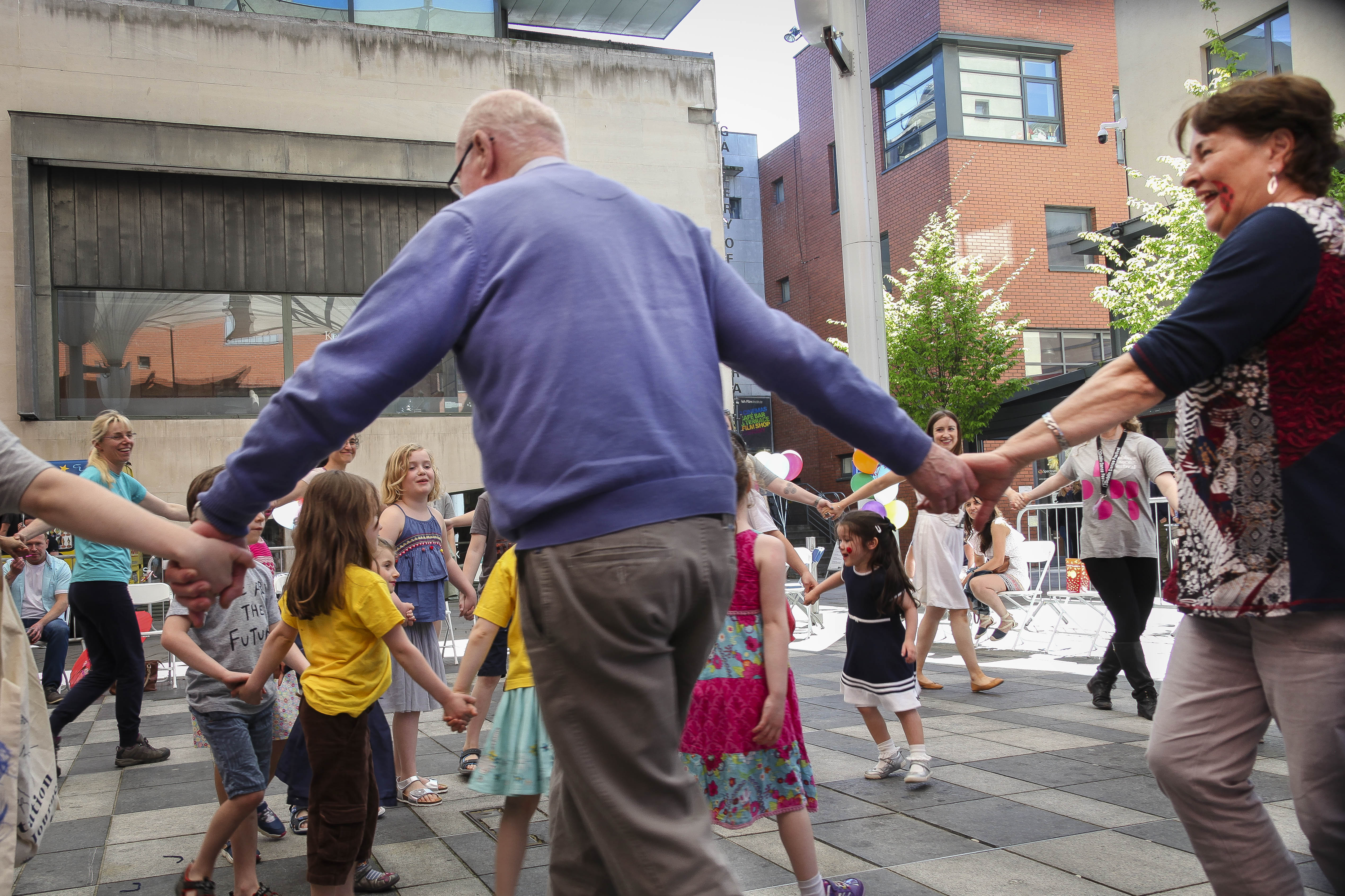 Older people and younger people dancing in Meeting House Square in Temple Bar, as part of a 2018 Bealtaine Festival event called a Life of Play.